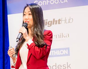 A woman holding a clicker and speaking to the audience.